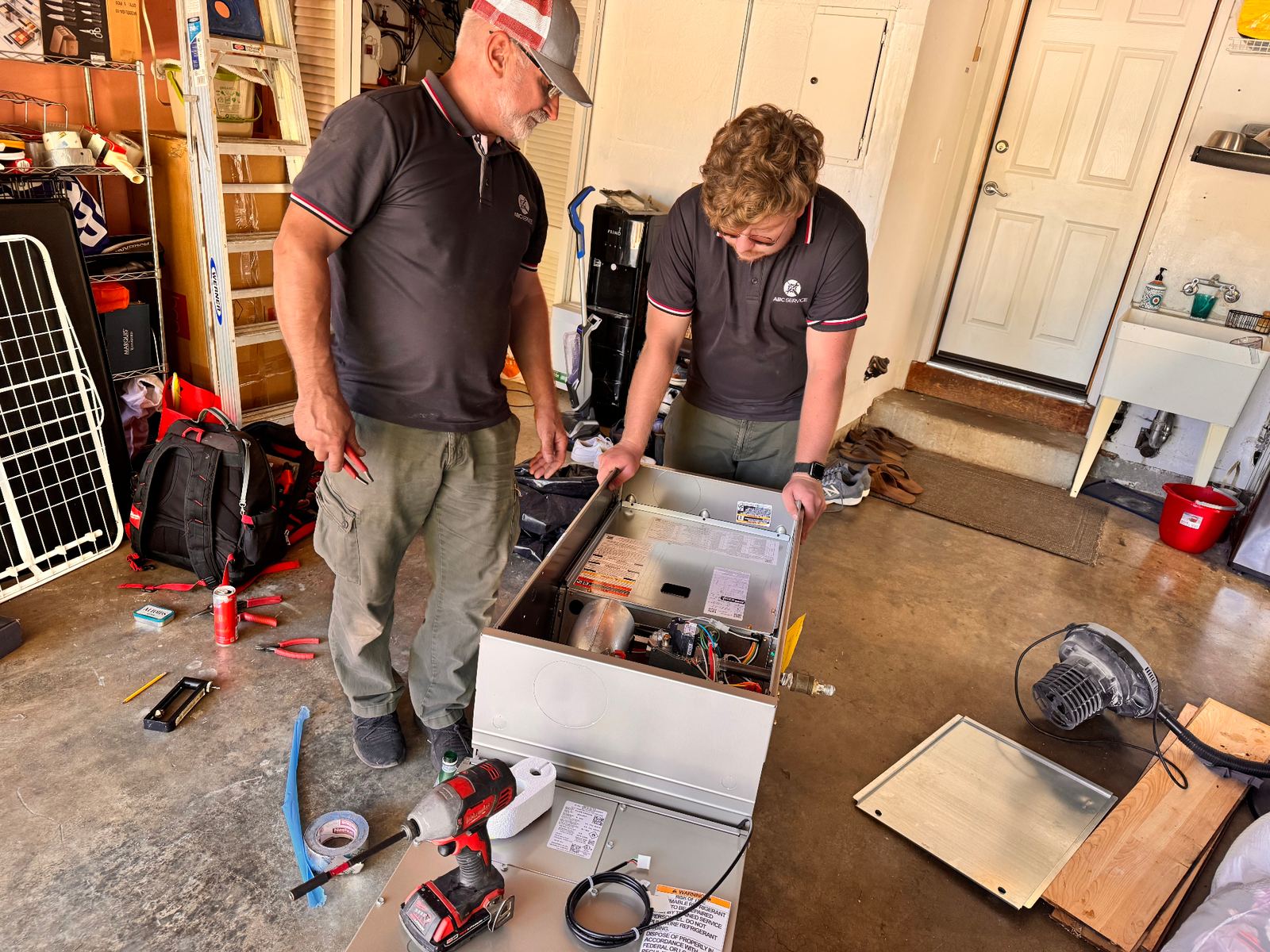 ABC Service technicians installing a new furnace in a Bay Area garage.