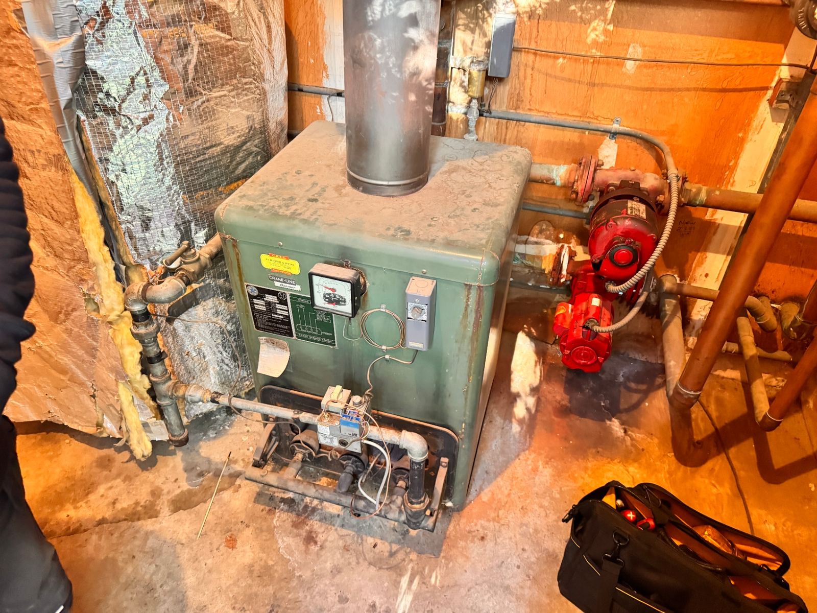 Vintage cast-iron atmospheric gas boiler with original Bell & Gossett circulator and copper near-boiler piping serviced by ABC Service in a Bay Area basement mechanical room.