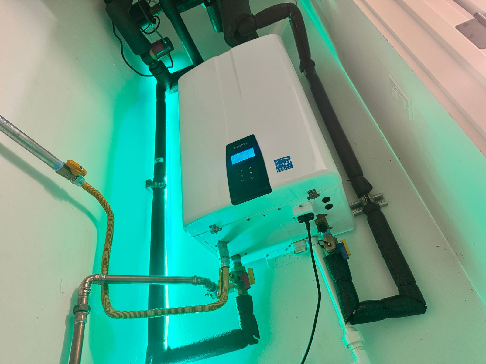 ABC Service technician servicing an open Navien NCB condensing combi unit with code-compliant copper piping, gas connection, and isolation valves in a Bay Area mechanical room.