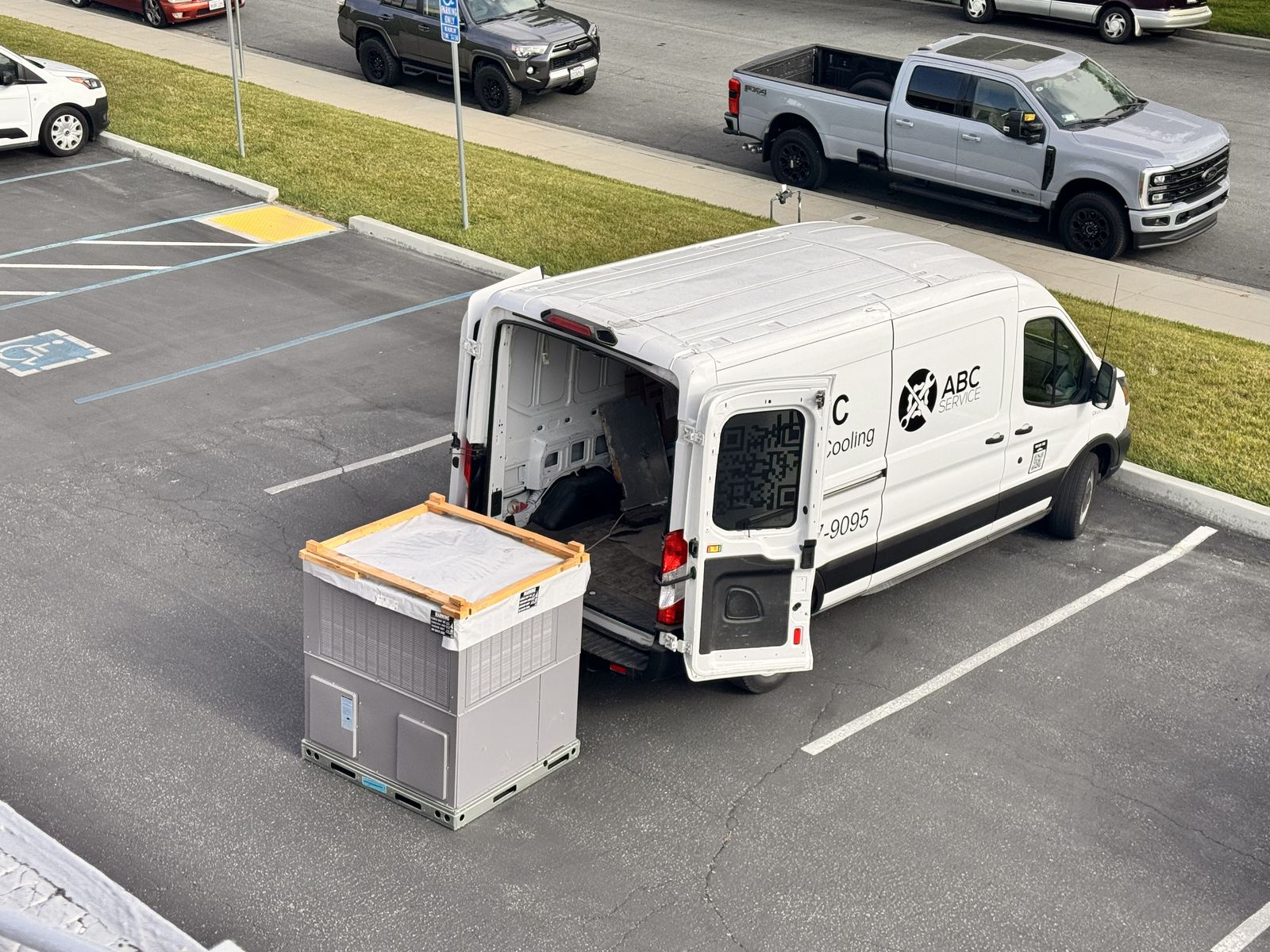 ABC Service technician installing a commercial rooftop packaged HVAC unit.